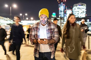 vibrant night scene with young man on cell phone