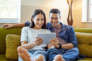 young couple at home watching shows on laptop