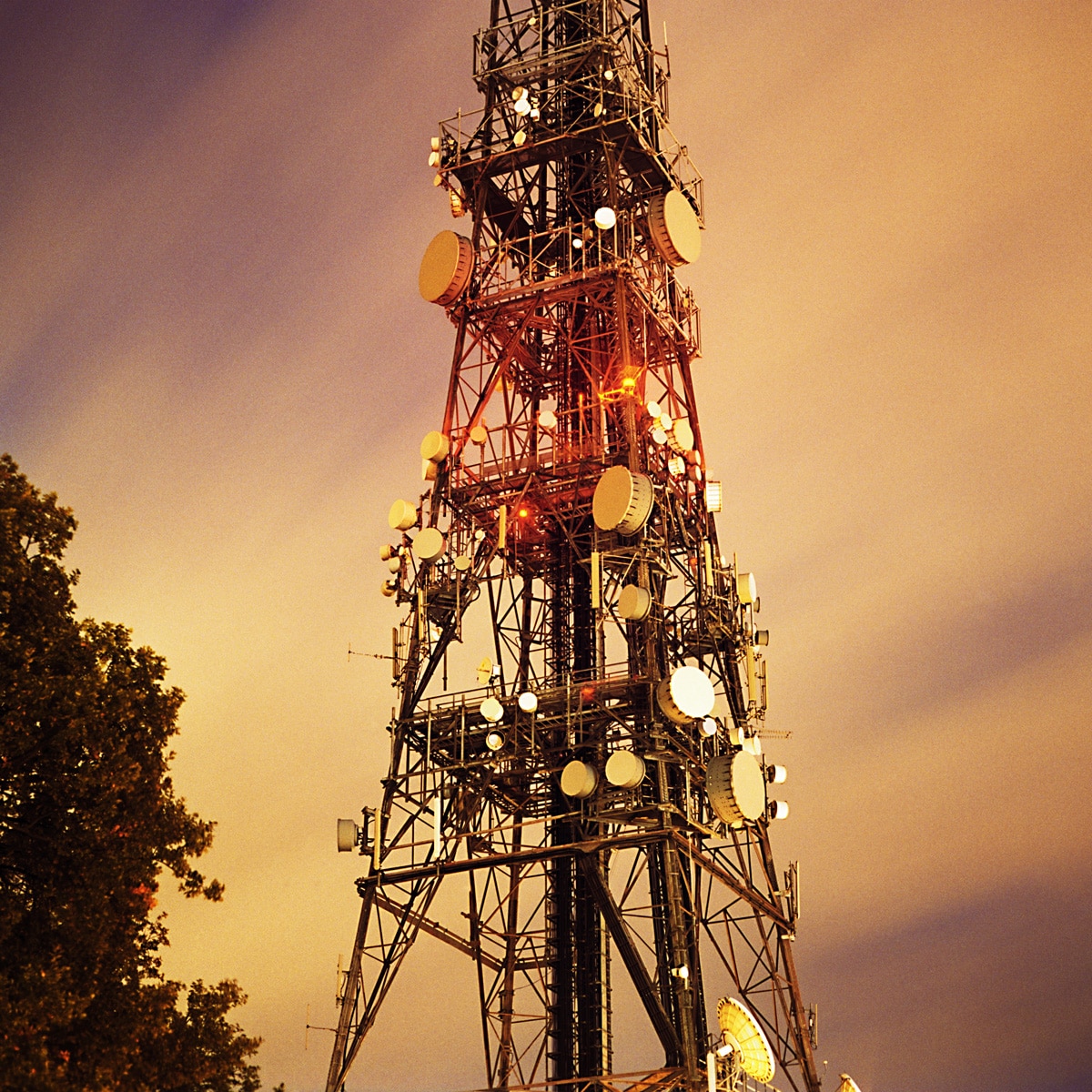 nighttime photo of broadcast tower with multiple antenna