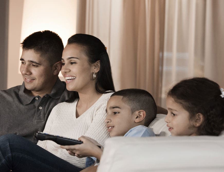 latin american family watching tv together