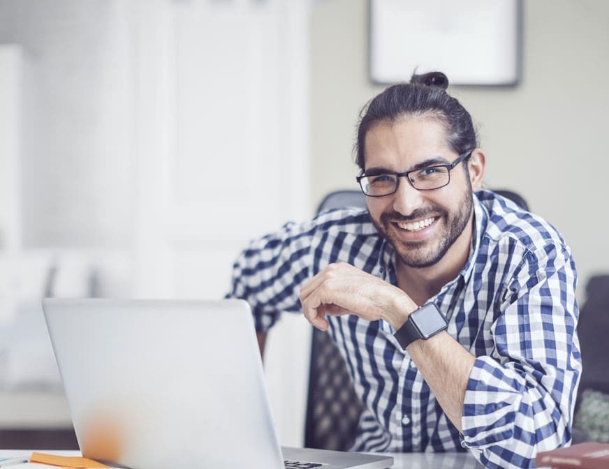 man wearing checked shirt at computer in office