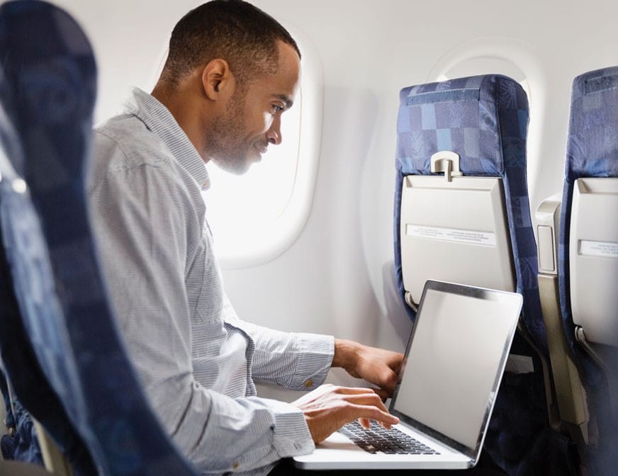 businessman on plan working on laptop