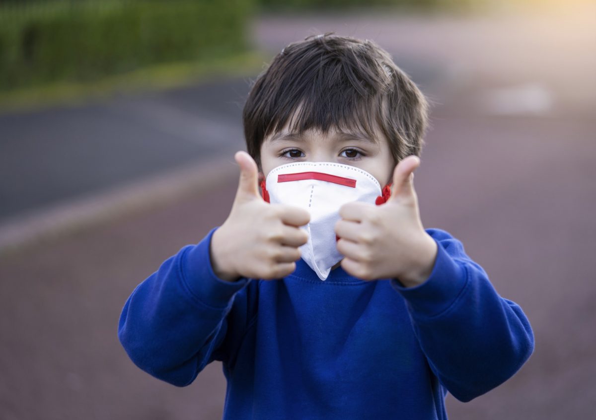 boy wearing mask and giving thumbs up during corona virus