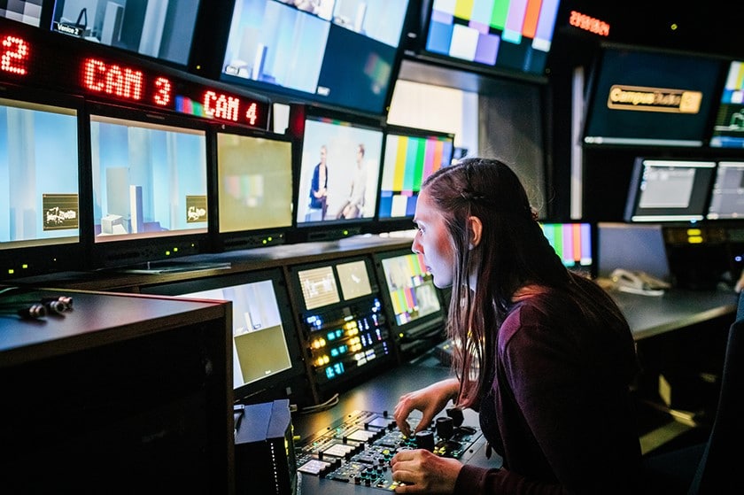 Producer in front of TV monitors