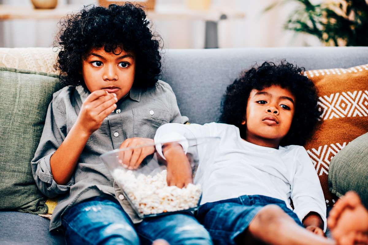kids watching tv and eating popcorn