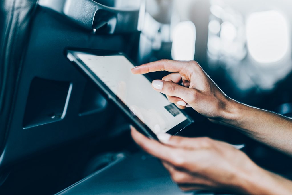 person using tablet on plane