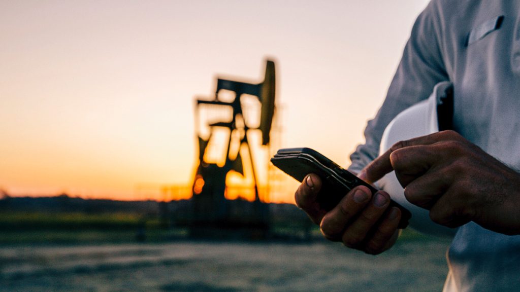 man on phone by oil rig