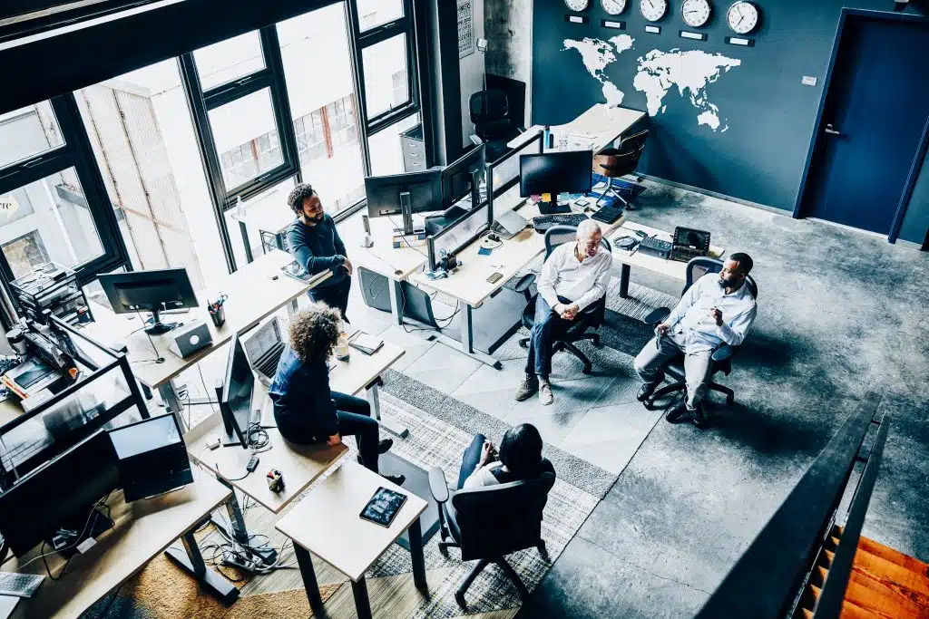 Coworkers having informal project meeting in high tech office overhead view