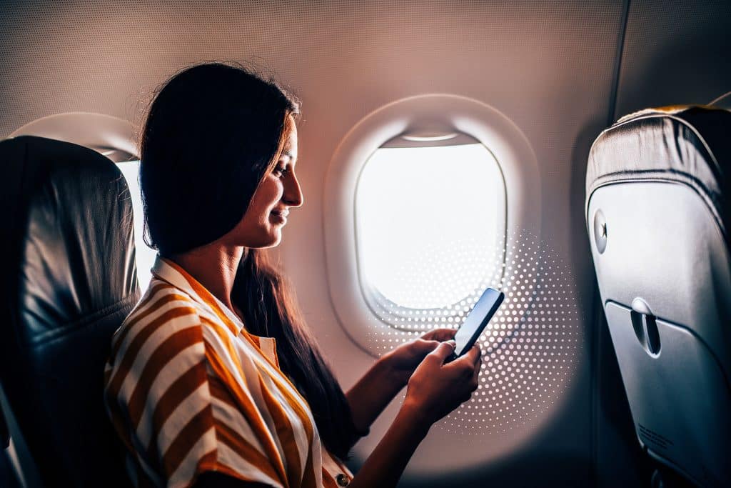airplane passenger using IFC on phone