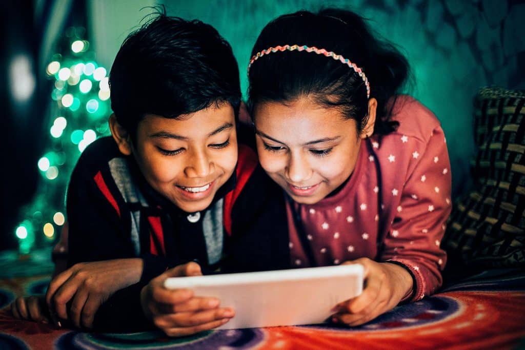 siblings streaming via satellite technology on a tablet